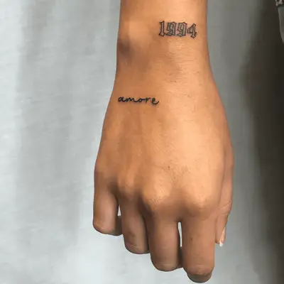 Imperfectly Perfect word tattoo on inner upper arm