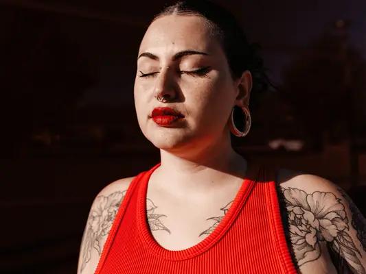 woman with red lipstick and flower tattoos