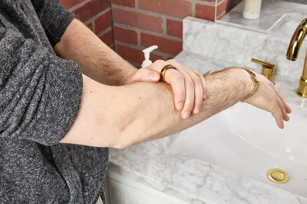 person applying Malin + Goetz Rum Body Lotion