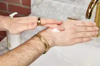 a person rubbing Malin + Goetz Rum Body Lotion onto their hand