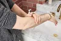 person applying Malin + Goetz Rum Body Lotion