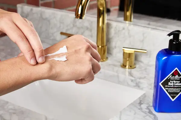 person applying Jack Black Cool Moisture Body Lotion to their hands