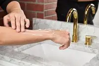 person applying Jack Black Cool Moisture Body Lotion to their arm