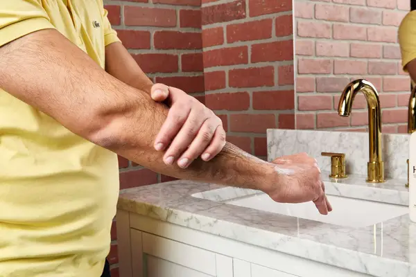 person applying Hempz Original Herbal Moisturizing Body Lotion to their arm