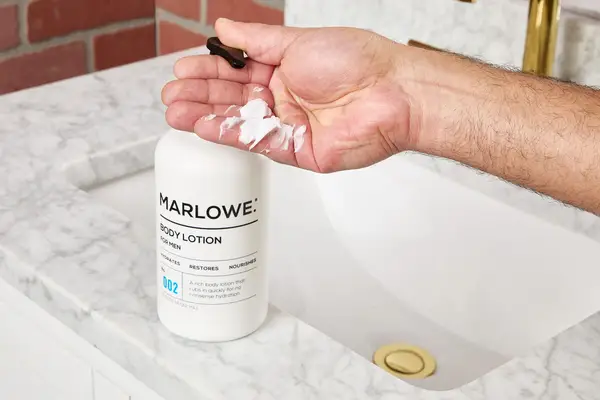 person dispensing Marlowe. No. 002 Sensitive Skin Body Lotion into palm