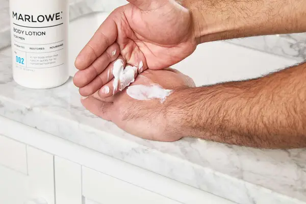 person applying Marlowe. No. 002 Sensitive Skin Body Lotion to their hand