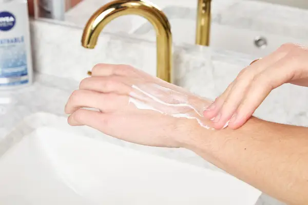 a person rubbing Nivea Men Breathable Body Lotion onto their arm