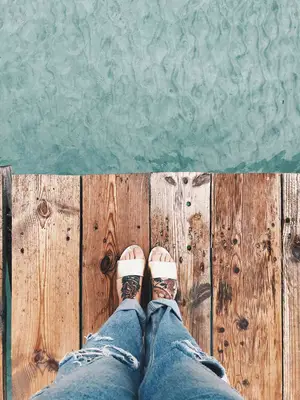 tattooed feet on dock overlooking water