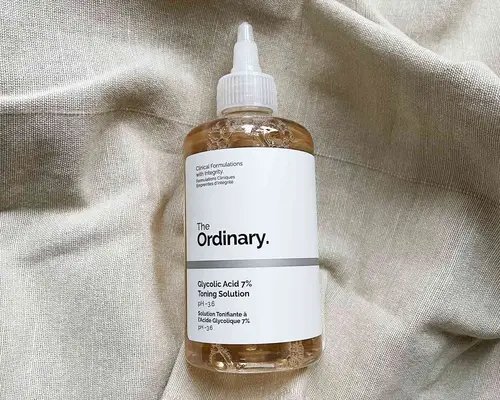 Bottle of The Ordinary Glycolic Acid 7% Toning Solution displayed on beige fabric
