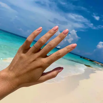 Person with a simple dotted ring finger tattoo