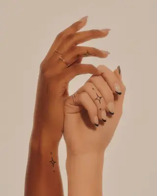 Two people with dazzling star tattoos on their fingers