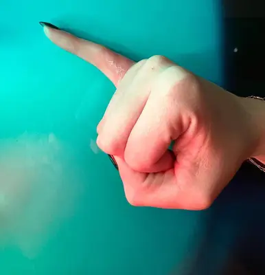 Person with a white word tattoo on finger