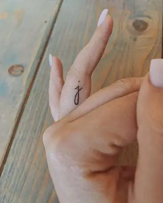 Person with a hidden letter ring finger tattoo
