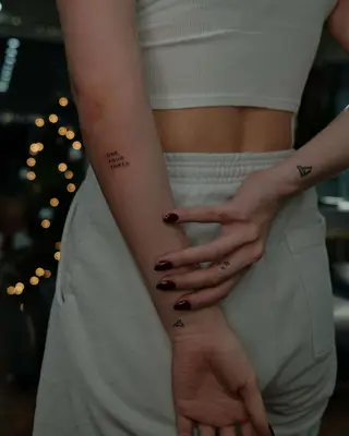 Person with cute cat tattoo on the ring finger