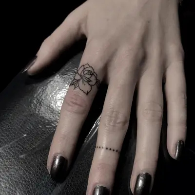 Person with a rose ring finger tattoo