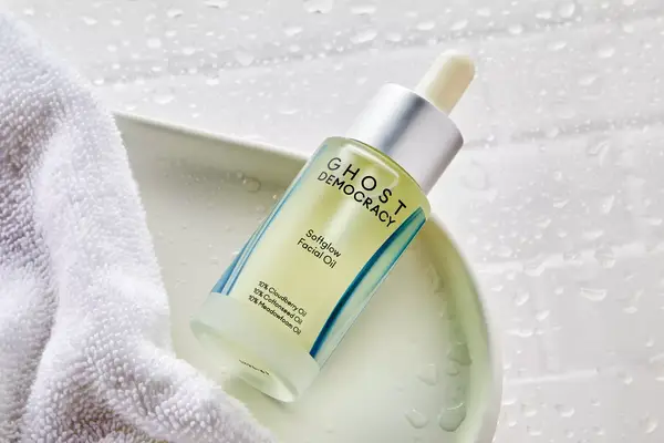 Ghost Democracy Softglow Facial Oil on a tray next to a towel 