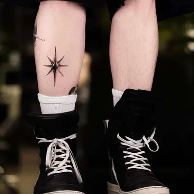 Star-shaped chrome tattoo on the back of the calf