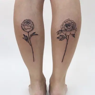 Two flower tattoos on the back of calves