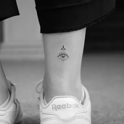 Orante eye tattoo on above the backside of the ankle