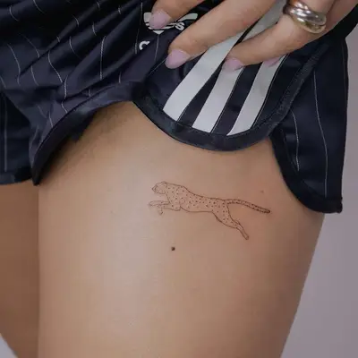 Delicate line tattoo of a jaguar on the thigh