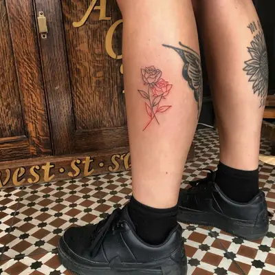 Calf tattoo of intertwined black and red roses