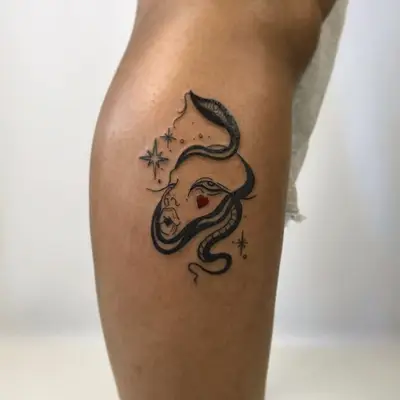 Abstract face tattoo on the lower leg