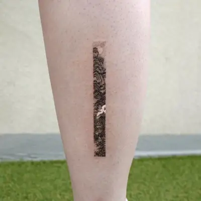 Delicate strip tattoo on the back of calf