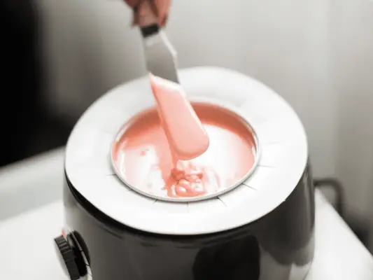 A warming machine of depilatory wax with a spatula in it