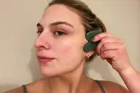 Person using a Skin Gym Jade Sculpty Heart Gua Sha Tool on their face