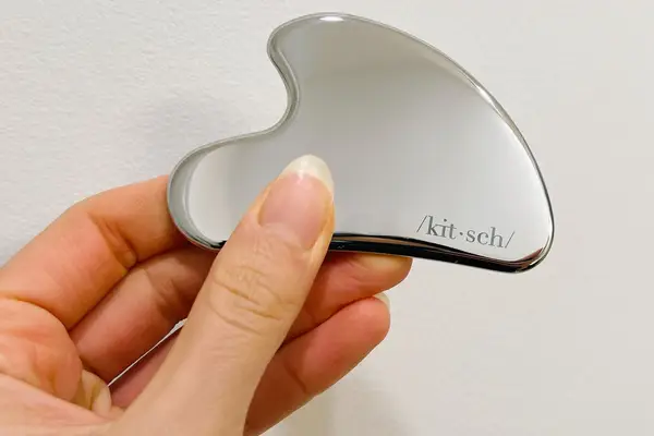 Close up of person holding a Kitsch Stainless Steel Gua Sha