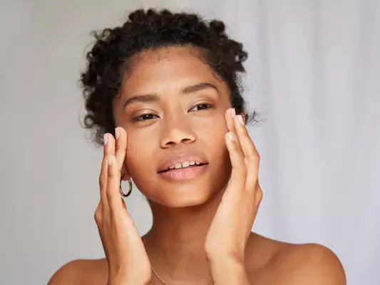 Close up of woman with clean skin touching her face