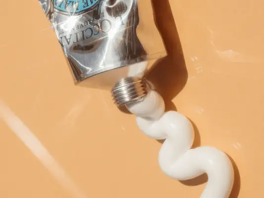 close up of shea butter cream on orange background.