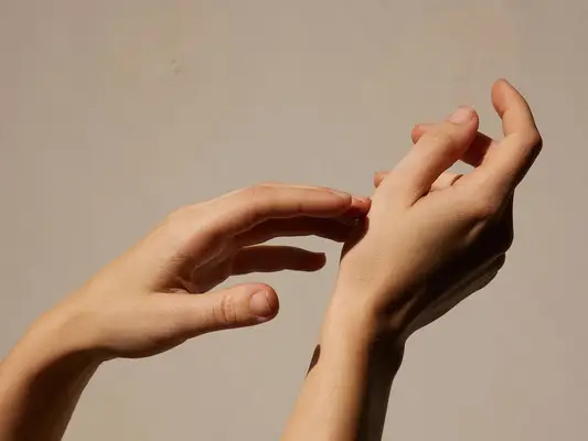 A pair of supple hands against a beige background