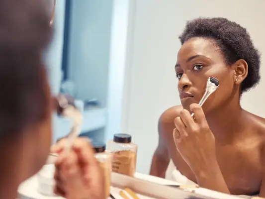 Close up of a woman microneedling her face
