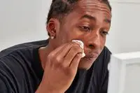 Person applying Simple Kind to Skin Micellar Cleansing Water to their face