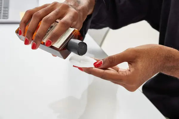 Person pouring Typology 7-Ingredient Micellar Water onto cotton round