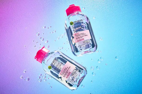 Two bottles of Garnier SkinActive Micellar Cleansing Water All-in-1 Cleanser & Makeup Remover displayed on a colorful background