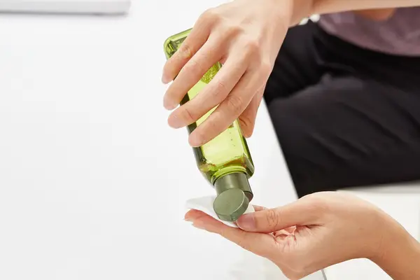 Hand dispensing Origins Mega-Mushroom Skin Relief Micellar Cleanser onto a cotton round