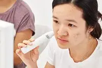 Person holding a hydration meter to their cheek