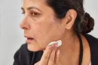 Person applying micellar water to their chin