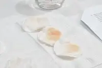 Several used cotton rounds displayed on a white towel