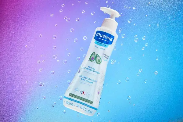 Mustela Baby Cleansing Water on purple and blue background