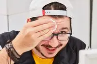 Person wiping face with a cotton round of micellar water