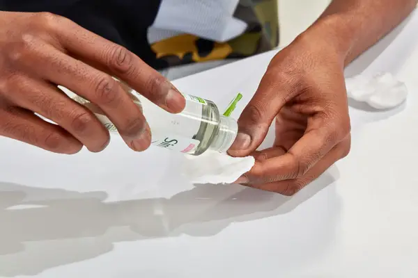 Hand dispensing Simple Kind to Skin Micellar Cleansing Water onto a cotton round