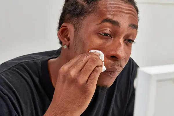 Person applying Simple Kind to Skin Micellar Cleansing Water to their face