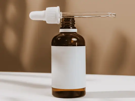 A serum bottle with a blank label and the dropper on top