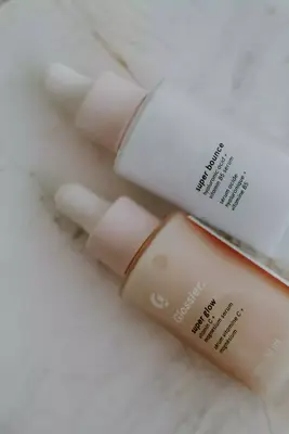 Glossier super glow and super bounce serums on a marble backgrouns