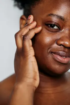 closeup portrait of woman touching clear skin