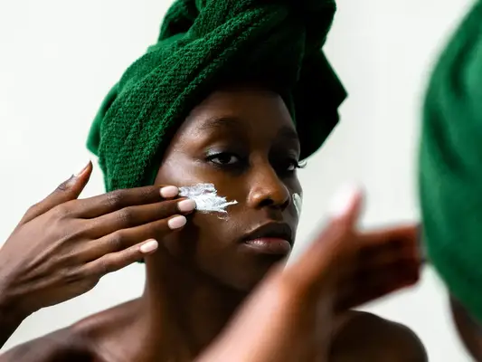 woman applying cream to her face