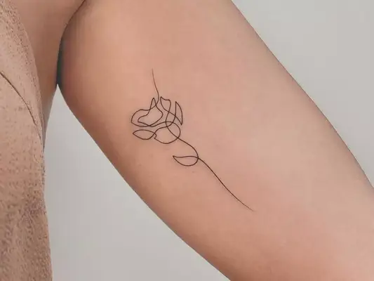 an abstract rose upper arm tattoo